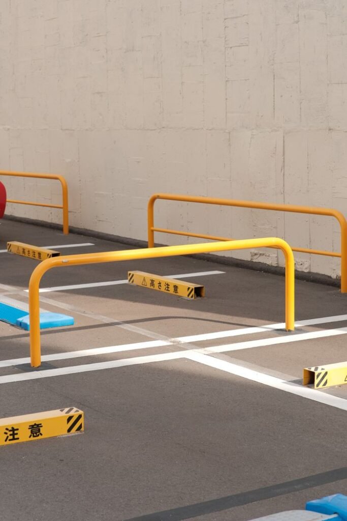 Empty parking lot featuring colorful barriers and safety markings in urban setting.